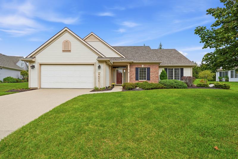 Brick ranch home with a two-car garage and mature trees