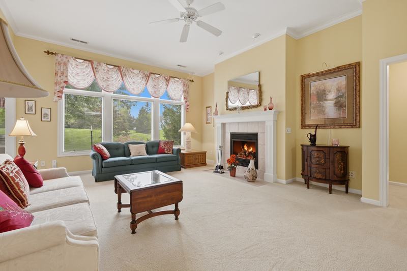 Traditional living room with a lit fireplace and large windows