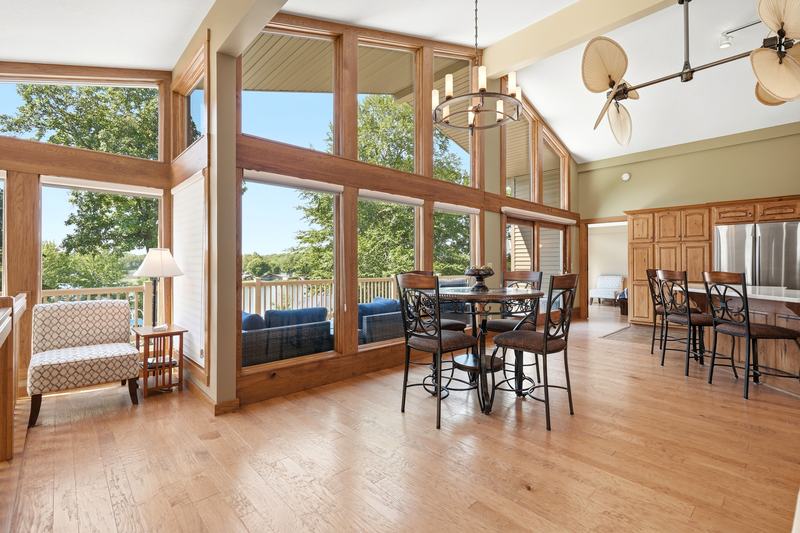 Dining room with a two-story wall of windows overlooking the trees