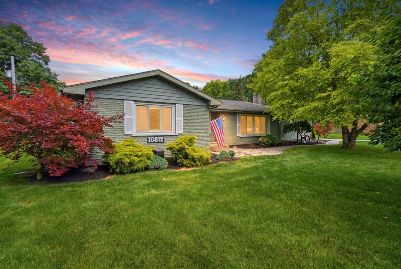 Twilight exterior of a blue-gray ranch home framed by a red Japanese maple